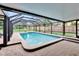 An enclosed pool surrounded by a brick paver patio and grassy backyard at 8222 Valrie Ln, Riverview, FL 33569