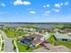 Aerial view showcases a community near a lake, with homes, manicured lawns, and a backyard basketball court at 8752 Loft Pt, Wesley Chapel, FL 33545