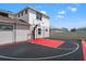 Rear view of a private backyard basketball court featuring a black and red surface with a hoop at 8752 Loft Pt, Wesley Chapel, FL 33545