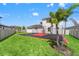 Grassy backyard featuring a basketball court, privacy fence, and some mature trees at 8752 Loft Pt, Wesley Chapel, FL 33545