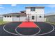 Backyard basketball court with a black and red surface and a basketball hoop at 8752 Loft Pt, Wesley Chapel, FL 33545