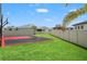Spacious backyard with a modern basketball court, lush lawn, and privacy fencing at 8752 Loft Pt, Wesley Chapel, FL 33545