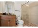 The bathroom features neutral tiling, a stone-look sink, and glass walk-in shower at 8752 Loft Pt, Wesley Chapel, FL 33545
