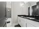 Modern bathroom with white cabinets, black hardware, and dual sinks at 8752 Loft Pt, Wesley Chapel, FL 33545
