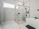 A modern bathroom boasts a glass enclosed shower, a soaking tub, and neutral finishes at 8752 Loft Pt, Wesley Chapel, FL 33545