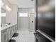 A modern bathroom featuring a dual sink vanity, marble floors, and a glass enclosed shower with marble wall surround at 8752 Loft Pt, Wesley Chapel, FL 33545