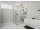 A bright bathroom showcases a glass enclosed shower with marble surround, a soaking tub, and black hardware fixtures at 8752 Loft Pt, Wesley Chapel, FL 33545