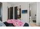 A bedroom showcasing black doors, wood floors, a TV, and an open bathroom with marble floors at 8752 Loft Pt, Wesley Chapel, FL 33545
