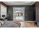 Modern bedroom with dark wood paneling and light wood floors leading to a view of the pool at 8752 Loft Pt, Wesley Chapel, FL 33545