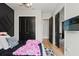 A bedroom featuring black double doors, wood floors, modern finishes, and stylish decor at 8752 Loft Pt, Wesley Chapel, FL 33545