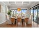 Dining room with coffered ceiling, elegant lighting, and sliding doors to a screened pool area at 8752 Loft Pt, Wesley Chapel, FL 33545