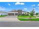 A two-story home with a well-manicured front yard, modern design, and a brick driveway at 8752 Loft Pt, Wesley Chapel, FL 33545