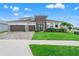 Stylish exterior featuring a well-kept lawn and a three-car garage at 8752 Loft Pt, Wesley Chapel, FL 33545