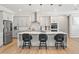 Modern kitchen with stainless steel appliances, a center island, and stylish bar stools, creating a functional space at 8752 Loft Pt, Wesley Chapel, FL 33545