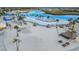Aerial view of a sandy beach lagoon with umbrellas, seating, and a volleyball court at 8752 Loft Pt, Wesley Chapel, FL 33545