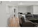 An open living area with plush seating, wood floors, recessed lighting, and open hall to an office space at 8752 Loft Pt, Wesley Chapel, FL 33545