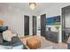 A living room features with black doors, wood floors, stylish TV, and accent lighting at 8752 Loft Pt, Wesley Chapel, FL 33545