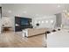 Spacious open-concept living room featuring fireplace, television, hardwood floors, and seamless flow to kitchen at 8752 Loft Pt, Wesley Chapel, FL 33545