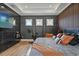 A stylish bedroom features a platform bed, wood paneled accent wall, and marble wall with a wall mounted flatscreen TV at 8752 Loft Pt, Wesley Chapel, FL 33545