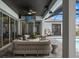 Inviting outdoor space with covered patio, TV, and comfortable seating area next to the pool at 8752 Loft Pt, Wesley Chapel, FL 33545
