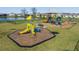 A sunny playground including slides and climbing areas set near a pond within the community at 8752 Loft Pt, Wesley Chapel, FL 33545