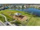 Aerial view of a playground with slides and swings near a pond, enhancing the community's appeal at 8752 Loft Pt, Wesley Chapel, FL 33545
