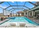 Sparkling screened-in pool with sun loungers, hot tub, and relaxing outdoor ambiance at 8752 Loft Pt, Wesley Chapel, FL 33545