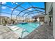 Stunning screened-in pool with a hot tub, outdoor cinema, and inviting patio area at 8752 Loft Pt, Wesley Chapel, FL 33545
