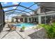 Luxurious screened-in pool area with a hot tub, poolside seating, and lush greenery at 8752 Loft Pt, Wesley Chapel, FL 33545