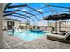 Inviting screened-in pool and spa with lounge chairs and an outdoor movie screen at 8752 Loft Pt, Wesley Chapel, FL 33545