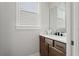 Powder room featuring a wood vanity with a white sink and modern fixtures at 8752 Loft Pt, Wesley Chapel, FL 33545
