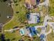 Aerial view showcasing a home with a backyard pool, a private dock, and verdant landscaping in a waterfront setting at 9011 Baywood Park Dr, Seminole, FL 33777