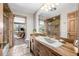 Bright bathroom with wood vanity, shower, and view of backyard pool at 9011 Baywood Park Dr, Seminole, FL 33777