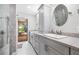 Elegant bathroom with double sinks, quartz counters, and a view to the outdoor deck and lush landscaping at 9011 Baywood Park Dr, Seminole, FL 33777