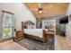 A serene bedroom with a wood-beamed ceiling, a large bed, and natural light from windows offering beautiful outdoor views at 9011 Baywood Park Dr, Seminole, FL 33777