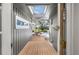 A bright breezeway with skylights connects indoor spaces to the screened-in pool and lake views at 9011 Baywood Park Dr, Seminole, FL 33777