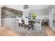 Chic dining room with stone accent wall, modern chandelier, and large window, creating an inviting atmosphere at 9011 Baywood Park Dr, Seminole, FL 33777