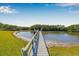 Private wooden dock extending into calm waters, surrounded by lush greenery and open skies at 9011 Baywood Park Dr, Seminole, FL 33777