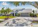 Beautiful home with a two-car garage and a brick-lined driveway surrounded by a lush lawn at 9011 Baywood Park Dr, Seminole, FL 33777