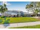 Well-manicured lawn and mature landscaping frame this home with an attached two-car garage at 9011 Baywood Park Dr, Seminole, FL 33777