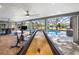 Game room featuring shuffleboard table, stationary bike, and access to outdoor pool at 9011 Baywood Park Dr, Seminole, FL 33777