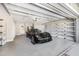 Well-organized garage featuring a black sports car, epoxy flooring, and ample storage space with shelving at 9011 Baywood Park Dr, Seminole, FL 33777