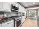 Well-appointed kitchen featuring white cabinets, stainless steel appliances, gas range, and gray subway tile backsplash at 9011 Baywood Park Dr, Seminole, FL 33777