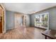 Living room featuring wood floors, wallpaper, large window, and paneled entryways at 9011 Baywood Park Dr, Seminole, FL 33777
