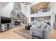 Spacious living room featuring a large stone fireplace, comfortable seating, and an open loft area above at 9011 Baywood Park Dr, Seminole, FL 33777