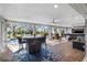 Enclosed outdoor living space featuring pool, bar seating, and multiple entertainment options at 9011 Baywood Park Dr, Seminole, FL 33777