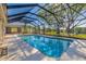 Large screened-in pool featuring views of the expansive yard and access to the lake at 9011 Baywood Park Dr, Seminole, FL 33777