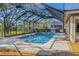 A beautiful, private pool enclosed in screened lanai with view of backyard and lake at 9011 Baywood Park Dr, Seminole, FL 33777