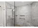 Modern glass enclosed shower featuring gray tiling, pebble flooring, and dual shower heads for a spa-like experience at 9011 Baywood Park Dr, Seminole, FL 33777