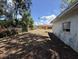 Backyard view features trees, an adjacent lot, ground debris, and an exterior view of a house at 902 Marshall St, Clearwater, FL 33755